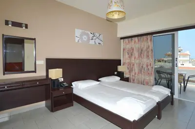 a bedroom with a large bed and a balcony at Ialysos City Hotel in Ialyssos