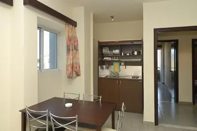 a kitchen and dining room with a table and chairs at Ialysos City Hotel in Ialyssos