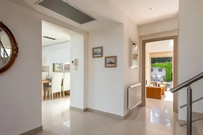 a hallway with white walls and a dining room at Vasiliki Villa in Ialyssos