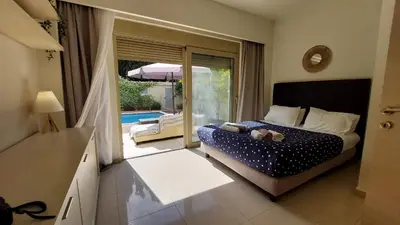 a bedroom with a bed and a view of a pool at Vasiliki Villa in Ialyssos