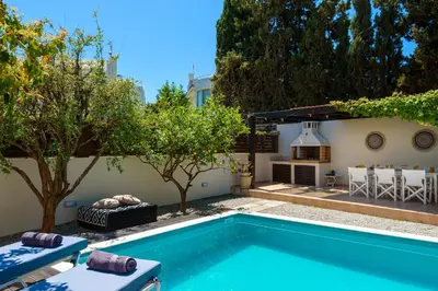 a backyard with a swimming pool and a house at Vasiliki Villa in Ialyssos