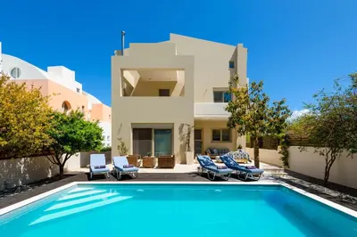 a villa with a swimming pool in front of a house at Vasiliki Villa in Ialyssos