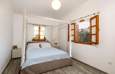 a bedroom with a white bed and a window at Lindos Seaside Villa in Líndos