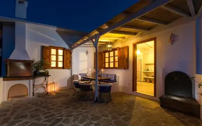 a dining room with a table and a fireplace at Lindos Seaside Villa in Líndos