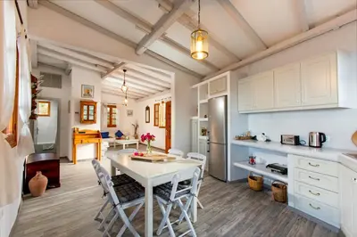 a kitchen and dining room with a table and chairs at Lindos Seaside Villa in Líndos