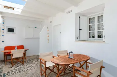 a dining room with a wooden table and chairs at Chrysanthi Studios in Líndos