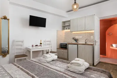 a room with a bed and a kitchen with towels at Chrysanthi Studios in Líndos