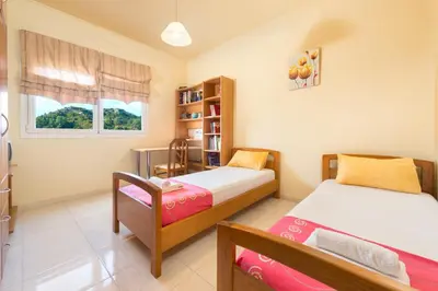 a bedroom with two beds and a book shelf at Natura House in Ialyssos