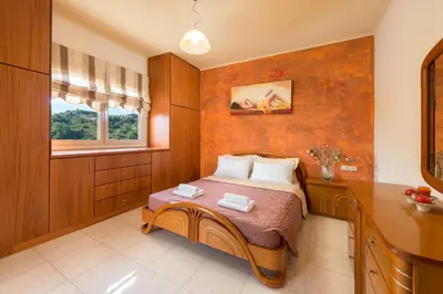 a bedroom with a bed and a desk and a window at Natura House in Ialyssos