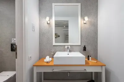 a bathroom with a white sink and a mirror at Lindos Comfy Suites in Líndos