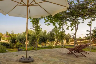a chair and an umbrella on a patio at Villa Dome in Gennadi