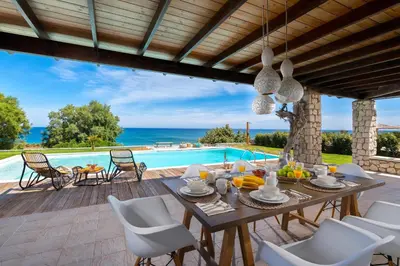 a patio with a table and chairs and a swimming pool at Villa Sevil in Lachania