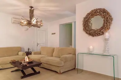 a living room with a couch and a table and a mirror at Villa Sevil in Lachania