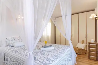 a bedroom with a white canopy bed with a candle on it at Villa Sevil in Lachania