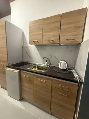 a small kitchen with wooden cabinets and a sink at Occasus Room in Halki