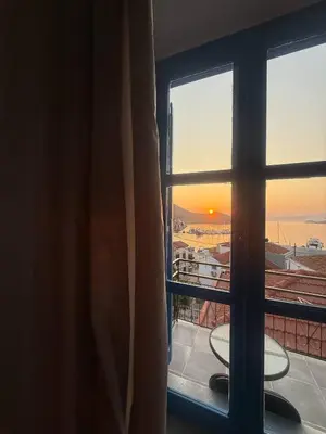 a room with a window looking out at the sunset at Occasus Room in Halki