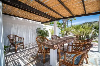 a patio with a wooden table and chairs on a porch at Mosaic Gardens in Faliraki