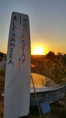 a boat sitting on the ground with the sunset in the background at Alexandra Homestay in Kalavárda