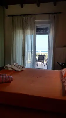 a bedroom with a bed with a view of the ocean at Alexandra Homestay in Kalavárda