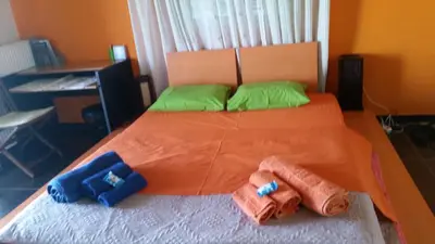 a bedroom with an orange bed with two pillows on it at Alexandra Homestay in Kalavárda