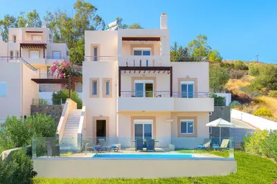a house with a swimming pool in front of it at Athoniki Villas in Kalathos