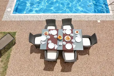 a table with plates of food next to a pool at Athoniki Villas in Kalathos