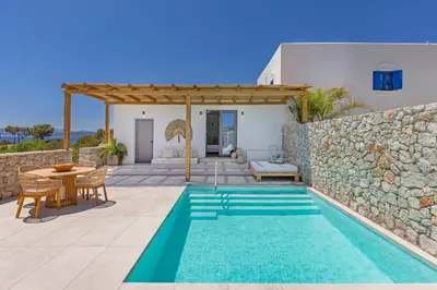 a villa with a swimming pool and a patio at Milos Villas Complex in Pefki Rhodes