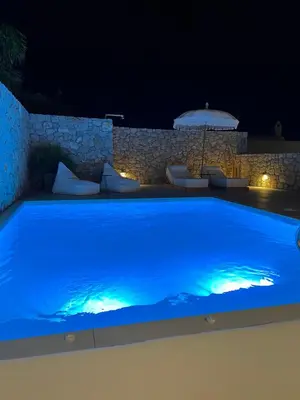a large blue swimming pool at night at Milos Villas Complex in Pefki Rhodes
