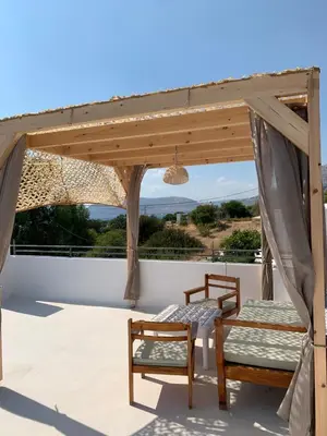 a pergola with two chairs and a table on a patio at Milos Villas Complex in Pefki Rhodes