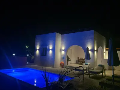 a villa with a swimming pool at night at Milos Villas Complex in Pefki Rhodes