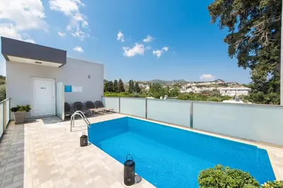 a swimming pool on the balcony of a house at Savvas Apartment in Afantou