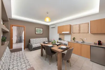 a kitchen and living room with a table and chairs at Savvas Apartment in Afantou
