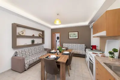a kitchen and living room with a table and a couch at Savvas Apartment in Afantou