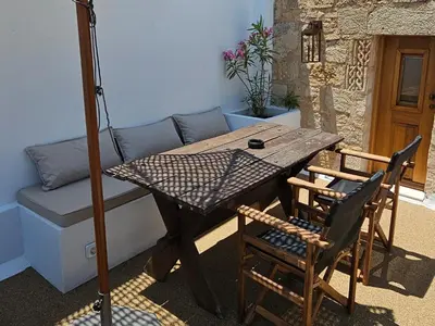 a table and chairs in a room with a couch at Villa Aphrodite Lindos Suites in Líndos