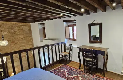 a room with a balcony with a table and chairs at Villa Aphrodite Lindos Suites in Líndos