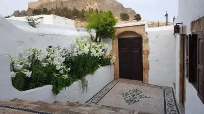 a door with flowers on the side of a building at Villa Aphrodite Lindos Suites in Líndos