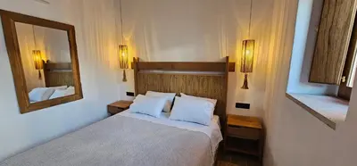 a hotel room with a bed and a mirror at Villa Aphrodite Lindos Suites in Líndos