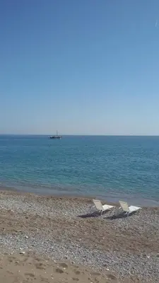 two chairs sitting on a beach near the water at Ktima Ellopia in Kolimbia