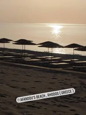 a group of umbrellas on a beach near the water at Ktima Ellopia in Kolimbia