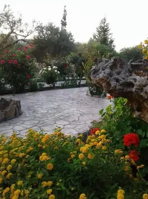 a garden with colorful flowers and a stone patio at Ktima Ellopia in Kolimbia