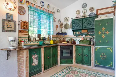 a kitchen with green cabinets and plates on the wall at Ktima Ellopia in Kolimbia