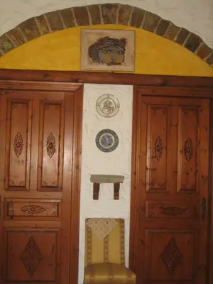 a room with two wooden doors and a chair at Ktima Ellopia in Kolimbia
