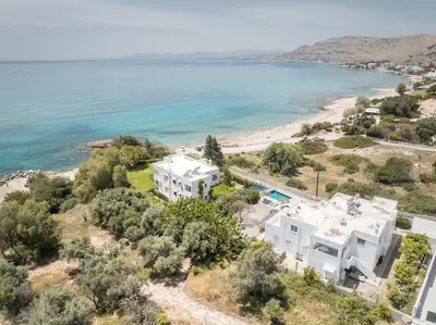 an aerial view of a white house next to a beach at Plakia Beach Apartments in Pefki Rhodes