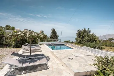 a villa with a swimming pool on a hill at Plakia Beach Apartments in Pefki Rhodes