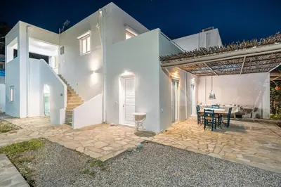 a white house with a patio and a table at Plakia Beach Apartments in Pefki Rhodes