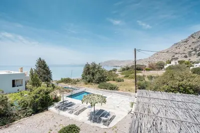a villa with a pool and a view of the ocean at Plakia Beach Apartments in Pefki Rhodes