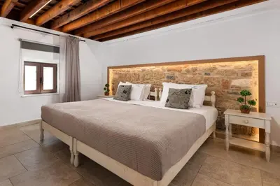 a bedroom with a bed and a brick wall at Lindos Citrin Studios in Líndos