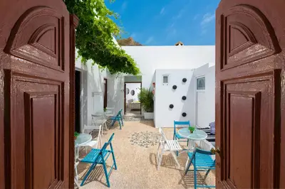 a courtyard with chairs and tables and a building at Lindos Citrin Studios in Líndos