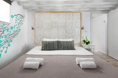 a bedroom with a large white bed with two pillows at Lindos Citrin Studios in Líndos