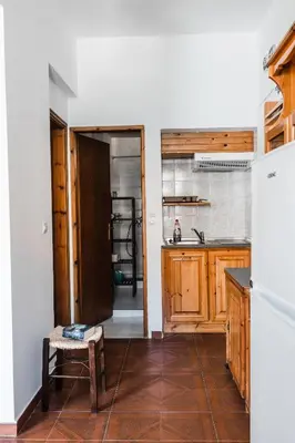 a kitchen with a refrigerator and a table in a room at Perla di Mare in Symi